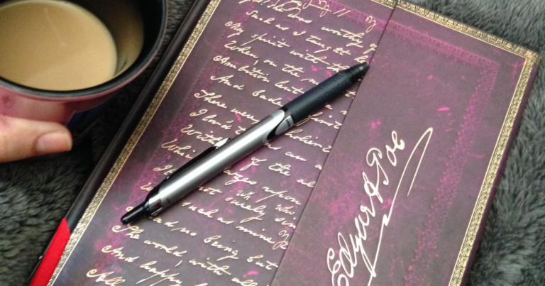 A decorative journal and coffee mug resting on a soft blanket — the quiet work of defining what matters.